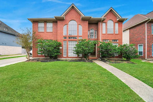 a front view of a house with a yard and trees