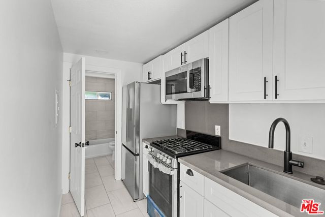 a kitchen with stainless steel appliances granite countertop a sink stove and microwave