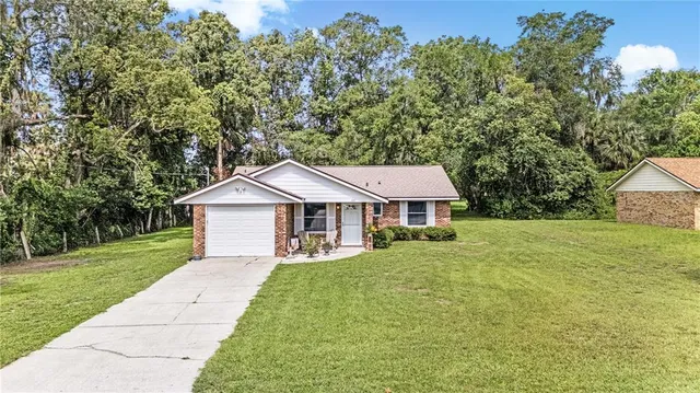 a front view of a house with a yard and trees