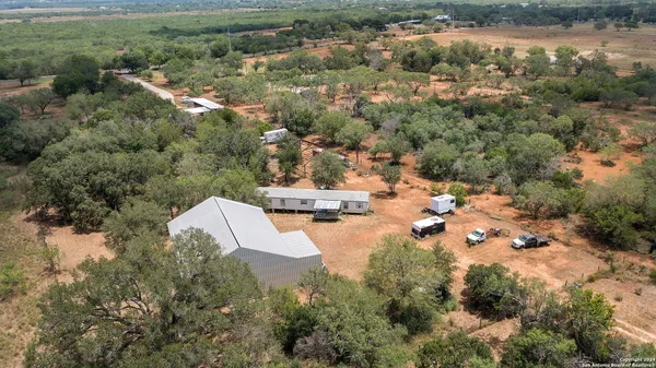 an aerial view of residential houses with outdoor space and trees