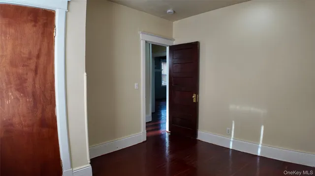 an empty room with wooden floor and closet