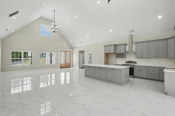 a kitchen with kitchen island granite countertop a sink stove and cabinets