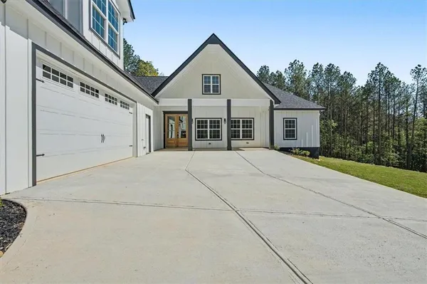 a view of house with yard and trees in the background