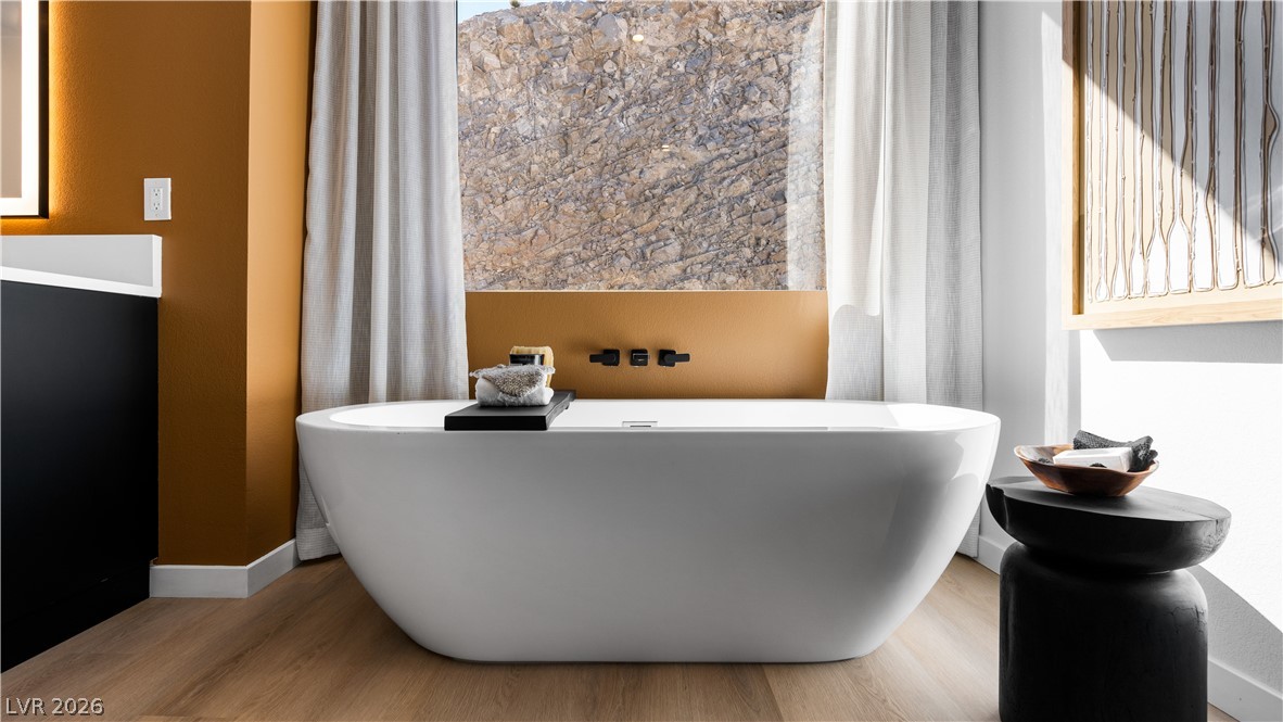 11099 Socrates Ridge Street Las Vegas, NV 89141 - Photo 14 of 29 This sleek bathroom boasts a deep soaking tub, perfect for unwinding in style.