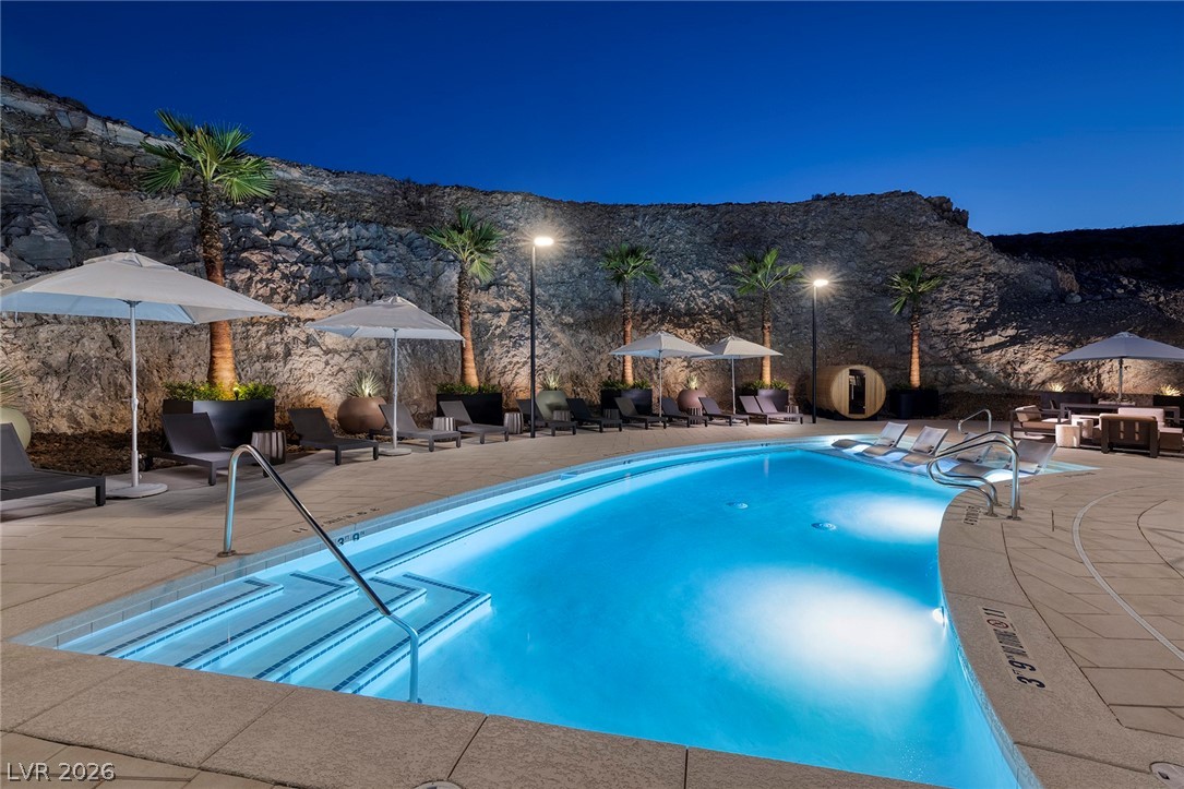 11099 Socrates Ridge Street Las Vegas, NV 89141 - Photo 24 of 29 This alluring pool area offers serene relaxation against a dramatic rocky backdrop, perfect for evening enjoyment.