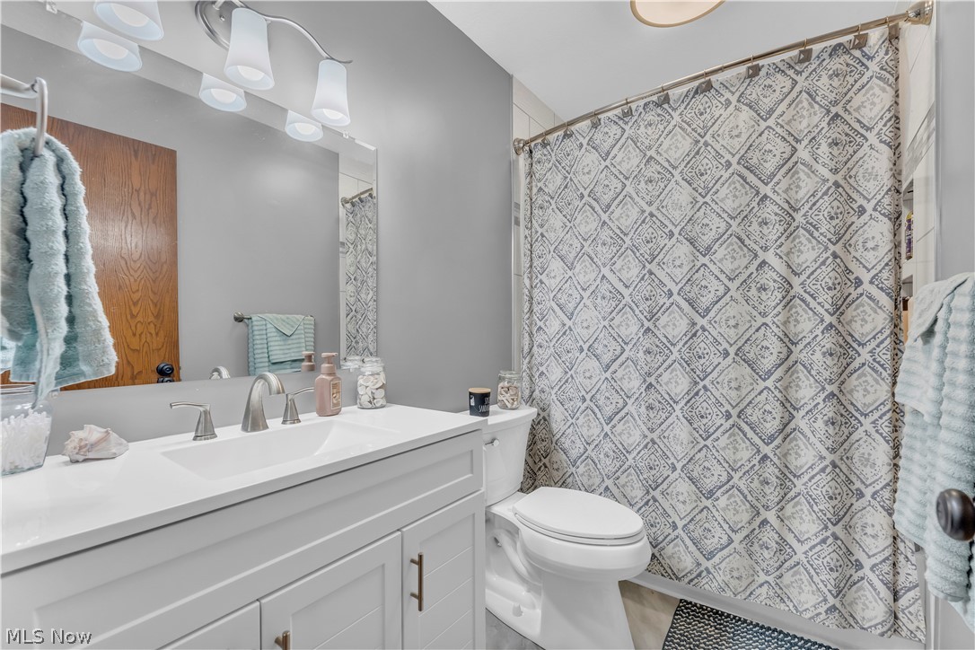 408 River Road Canal Fulton, OH 44614 - Photo 24 of 42 Bathroom featuring a white vanity with an integrated sink, brushed nickel faucet, and a large mirror with multi-bulb vanity lighting