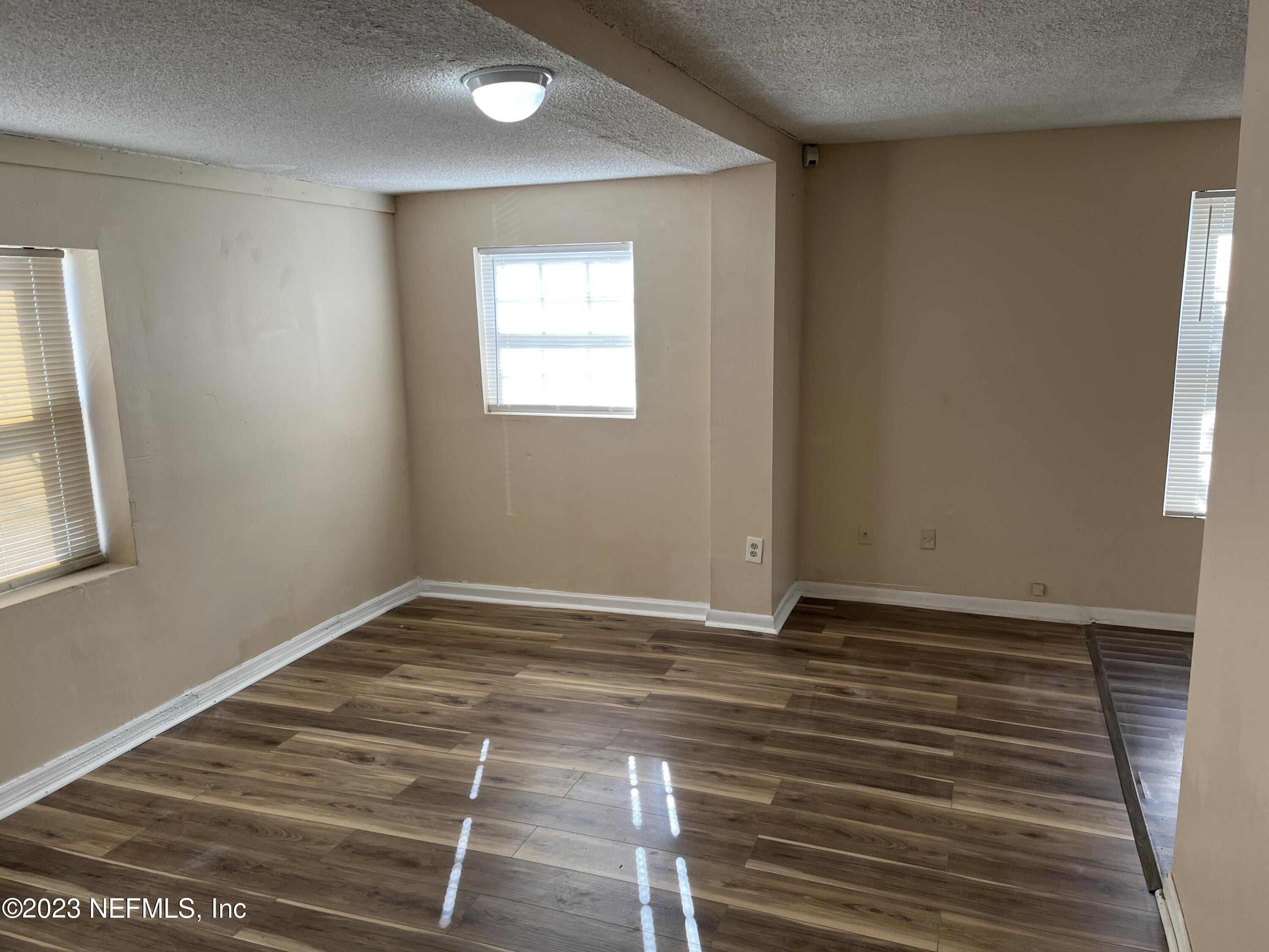 3716 Stuart Street Jacksonville, FL 32209 - Photo 6 of 13 a view of an empty room with wooden floor and a window