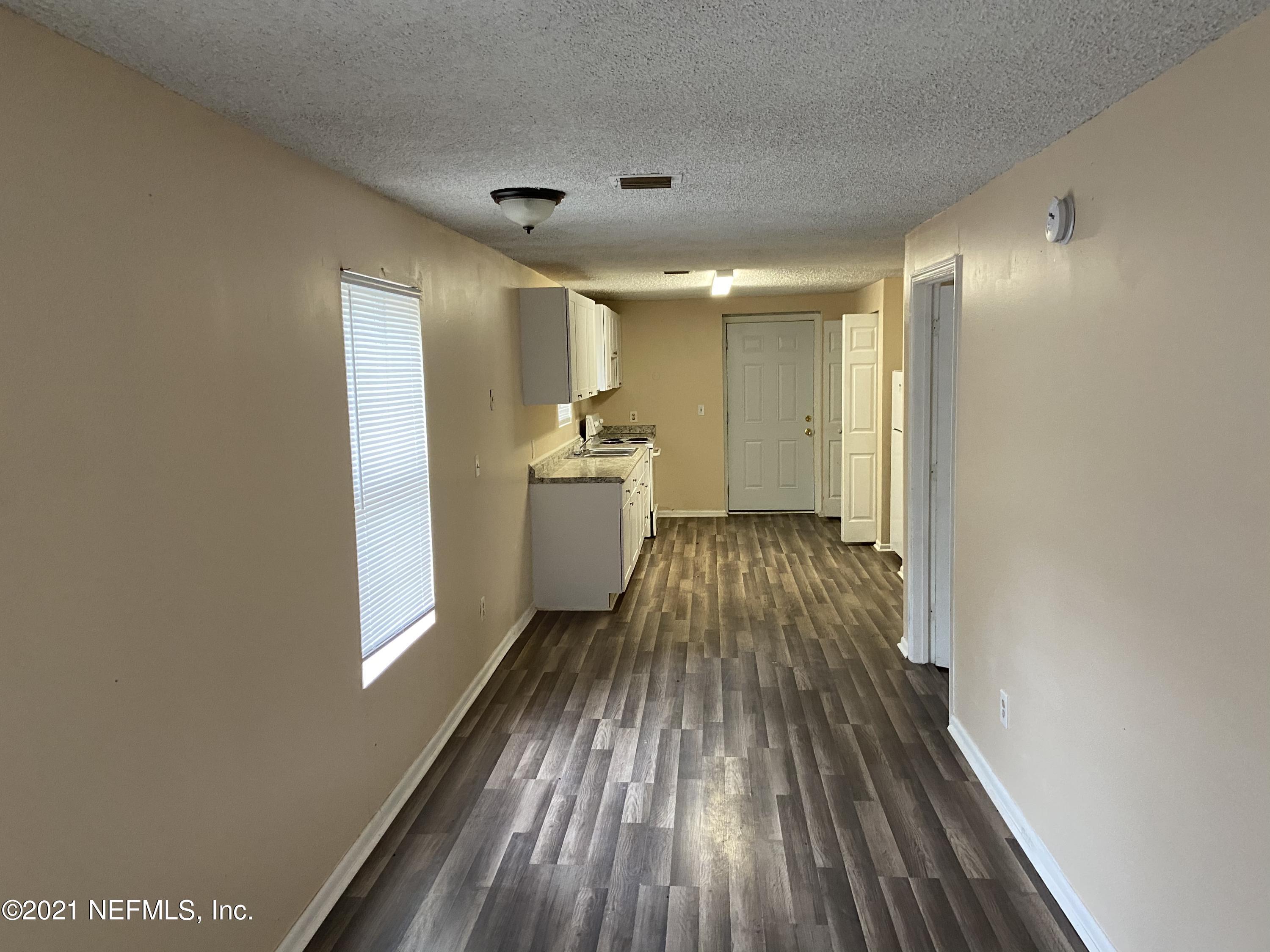 3716 Stuart Street Jacksonville, FL 32209 - Photo 9 of 13 a view of a room with wooden floor a ceiling fan and staircase
