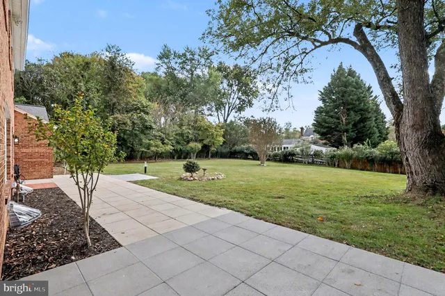 a view of a house with a big yard and large trees