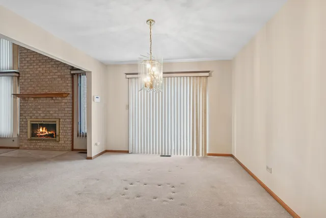 a view of empty room with fireplace and window