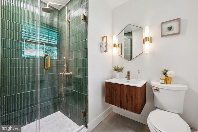 a bathroom with a toilet sink vanity and mirror