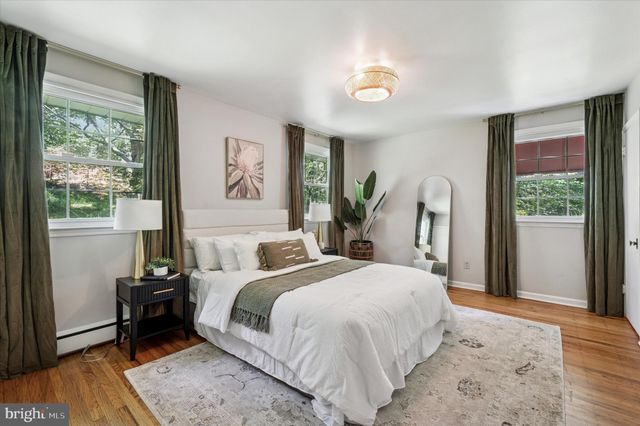 a bedroom with a bed wooden floor and window