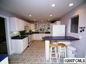 4311 Castlewood Road Charlotte, NC 28209 - Photo 2 of 8 a kitchen with a refrigerator a counter top space and cabinets