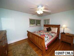 4311 Castlewood Road Charlotte, NC 28209 - Photo 5 of 8 a bedroom with a bed and a chandelier