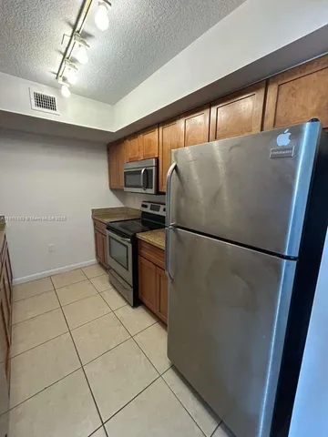 a kitchen with a refrigerator a stove top oven and a counter top space