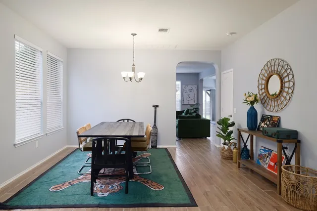 a view of a dining room with furniture a chandelier and wooden floor