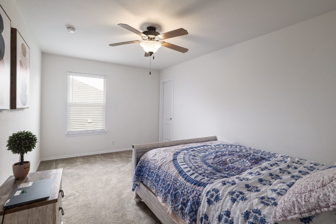 8716 Panadero Drive Austin, TX 78747 - Photo 23 of 36 Carpeted bedroom featuring baseboards and ceiling fan