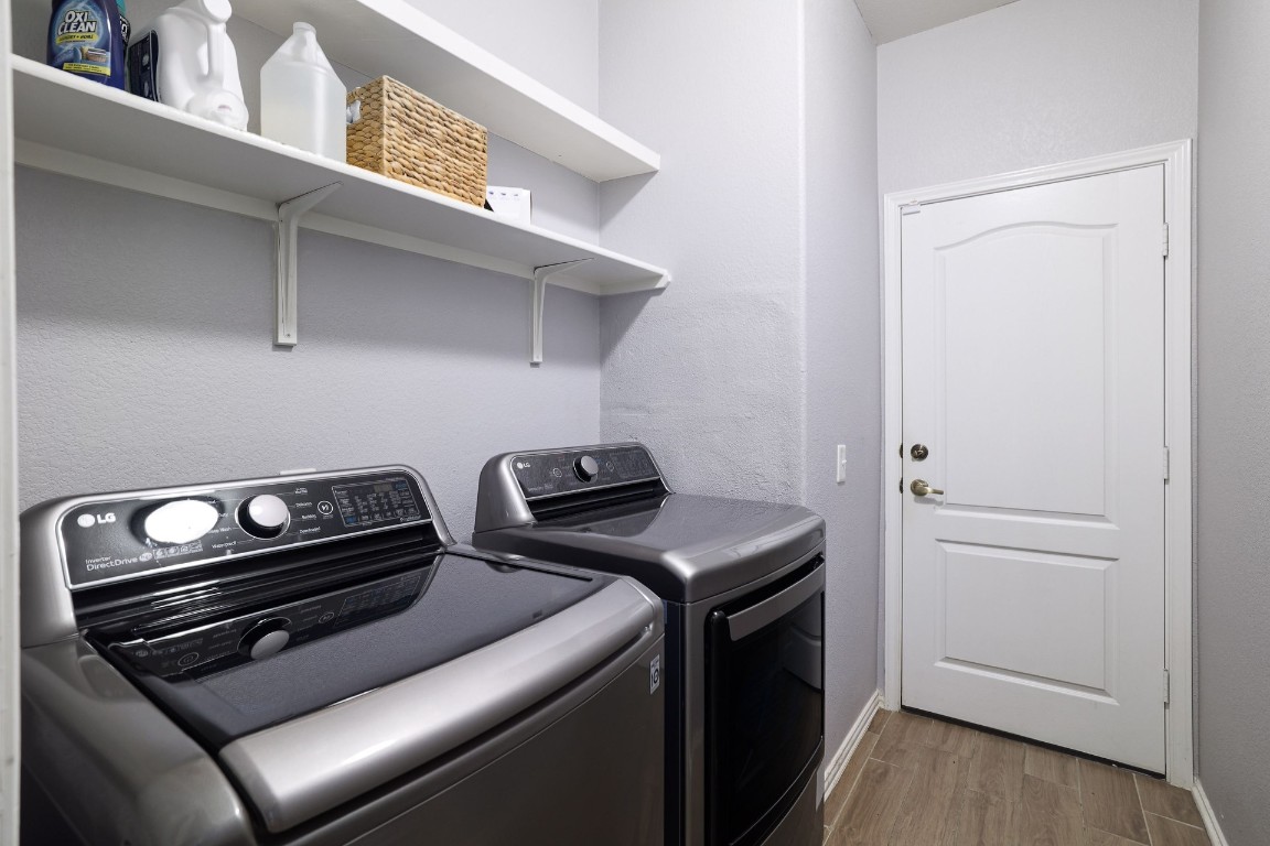 8716 Panadero Drive Austin, TX 78747 - Photo 26 of 36 Washroom featuring wood finished floors, independent washer and dryer, and a textured wall