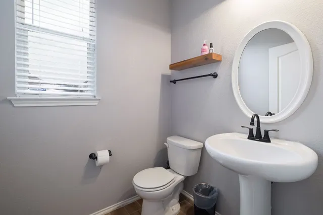 a bathroom with a toilet sink and mirror