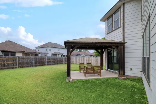 a view of a house with backyard and a tree