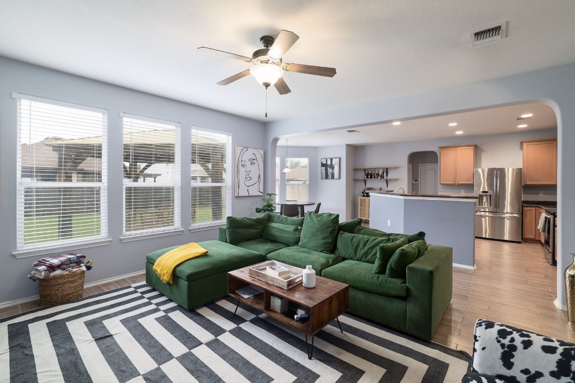 8716 Panadero Drive Austin, TX 78747 - Photo 6 of 36 Living area featuring arched walkways, light wood-style flooring, a ceiling fan, and recessed lighting