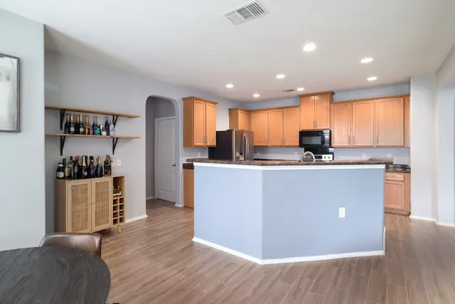 a view of kitchen with cabinets stainless steel appliances and wooden floor