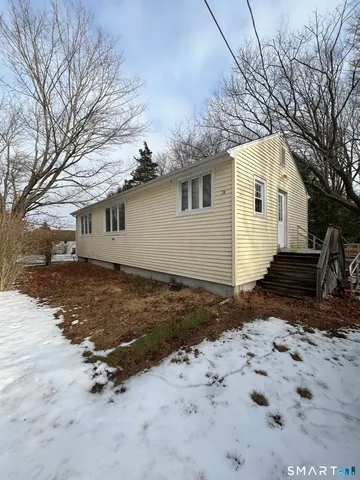 a view of a house with a yard covered in snow