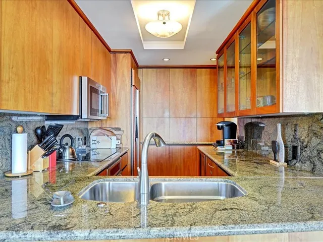 a kitchen with stainless steel appliances granite countertop a sink and a granite counter tops with a large window