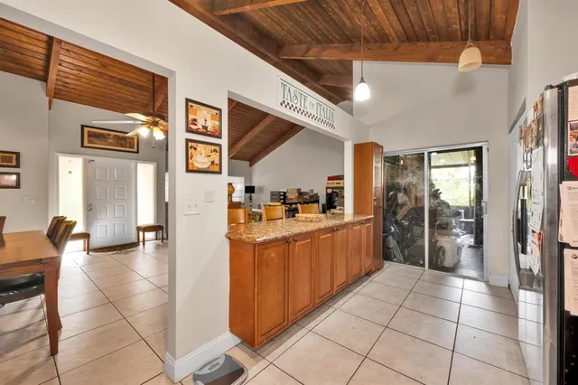 a large kitchen with stainless steel appliances granite countertop a refrigerator and a sink
