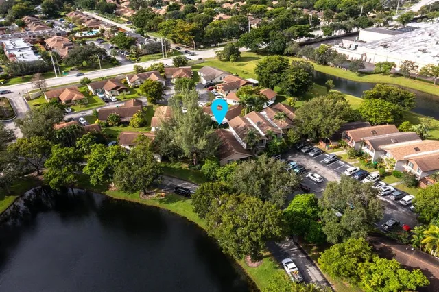 an aerial view of residential houses with outdoor space and trees