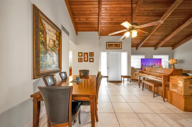 a dining room with a wooden table and chairs