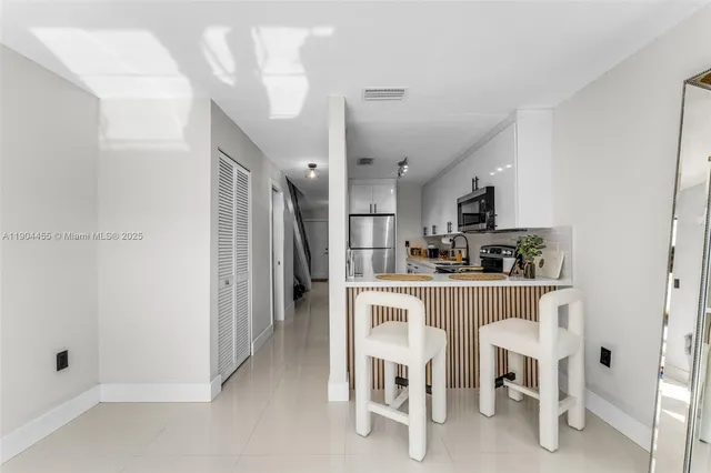 a kitchen with refrigerator and chairs