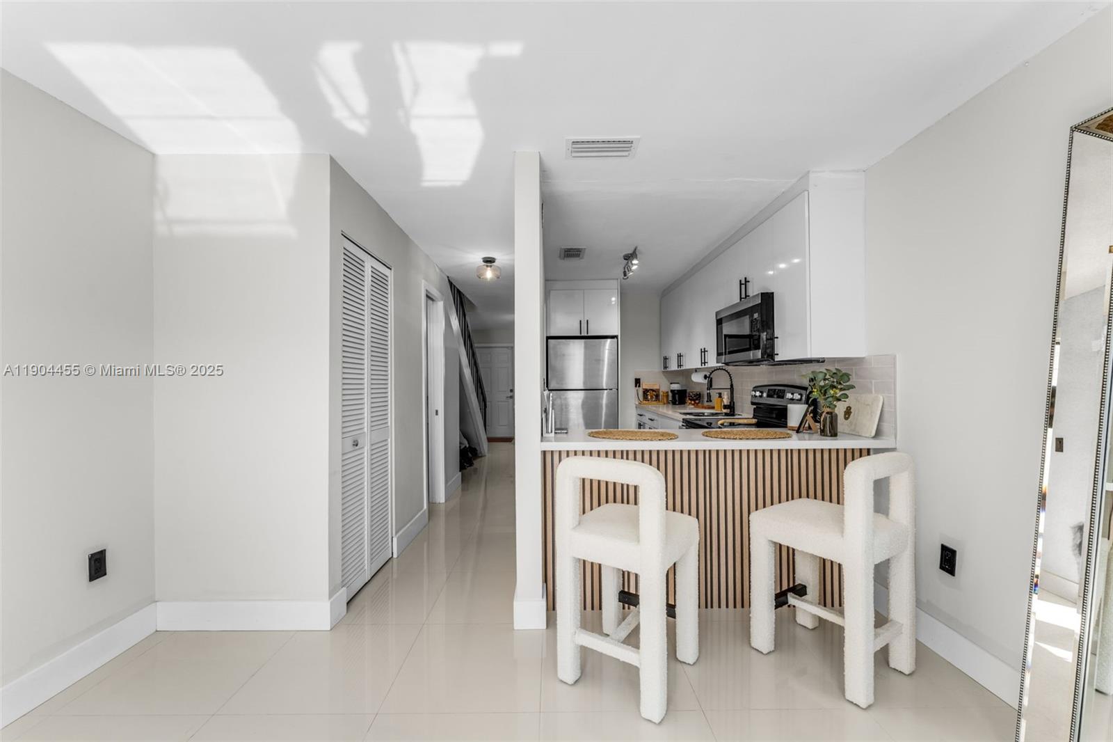 13350 Southwest 58th Terrace, Unit 38 Miami, FL 33183 - Photo 3 of 8 a kitchen with refrigerator and chairs