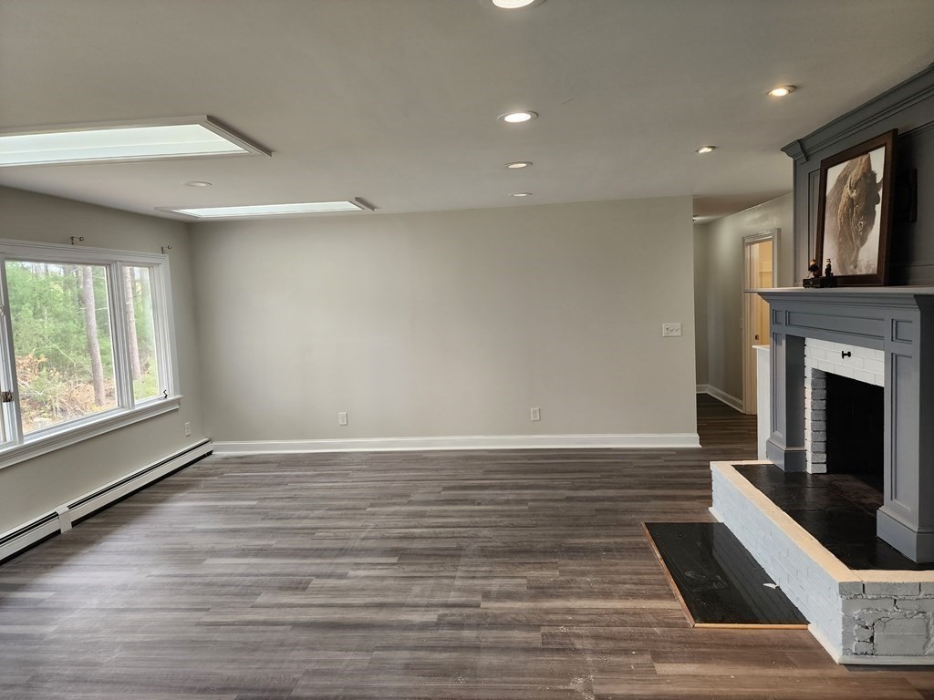 81 Onset Avenue Wareham, MA 02532 - Photo 16 of 42 an empty room with wooden floor fireplace and windows