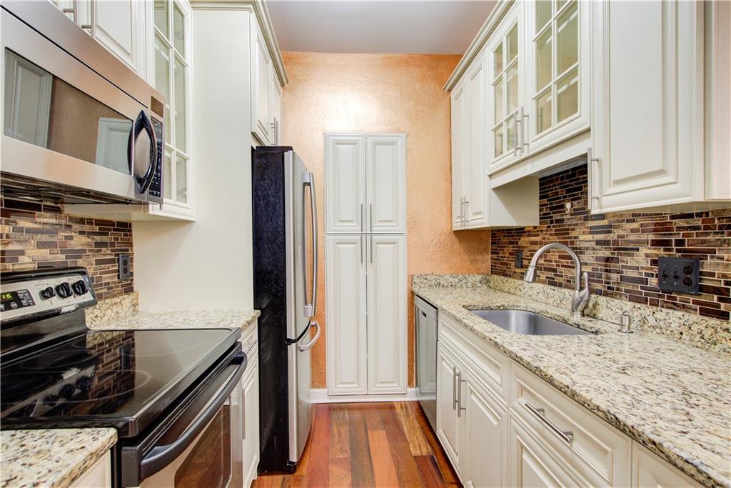 2865 Lenox Road Northeast, Unit 102 Atlanta, GA 30324 - Photo 5 of 35 a kitchen with granite countertop stainless steel appliances and a sink