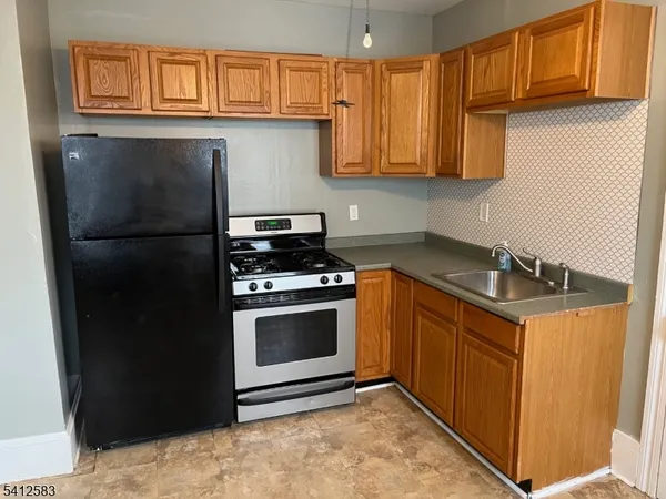 a kitchen with stainless steel appliances granite countertop a refrigerator a stove a sink and dishwasher