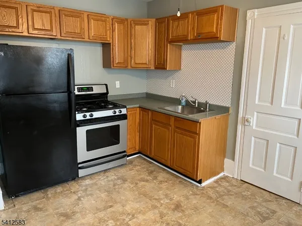 a kitchen with stainless steel appliances granite countertop a stove a refrigerator and a cabinets