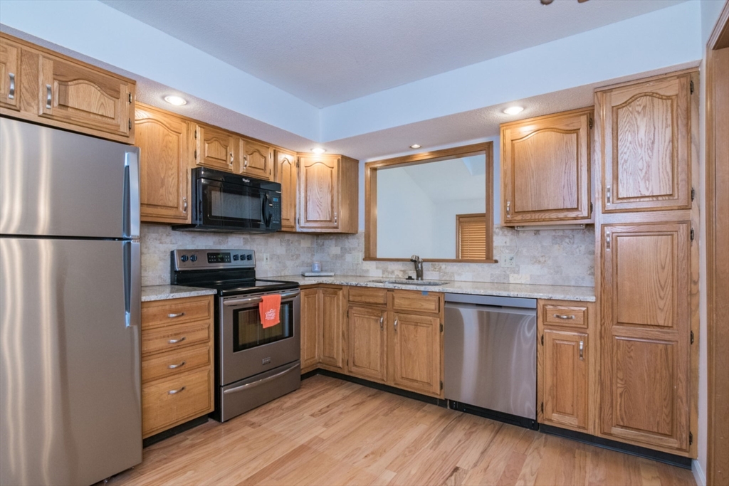 14 B Castle Hills Road, Unit 14B Agawam, MA 01001 - Photo 12 of 31 a kitchen with stainless steel appliances granite countertop a refrigerator a stove a sink and a microwave