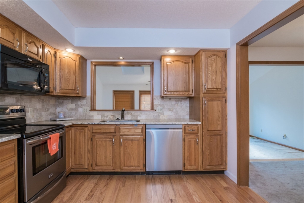 14 B Castle Hills Road, Unit 14B Agawam, MA 01001 - Photo 13 of 31 a kitchen with stainless steel appliances granite countertop wooden cabinets a sink and dishwasher a stove with wooden floor