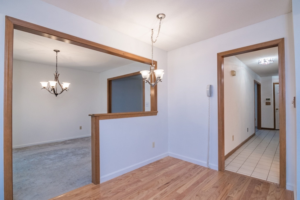 14 B Castle Hills Road, Unit 14B Agawam, MA 01001 - Photo 14 of 31 wooden floor in an empty room with a mirror