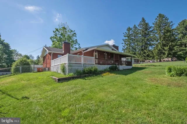 a front view of house with yard and trees in the background