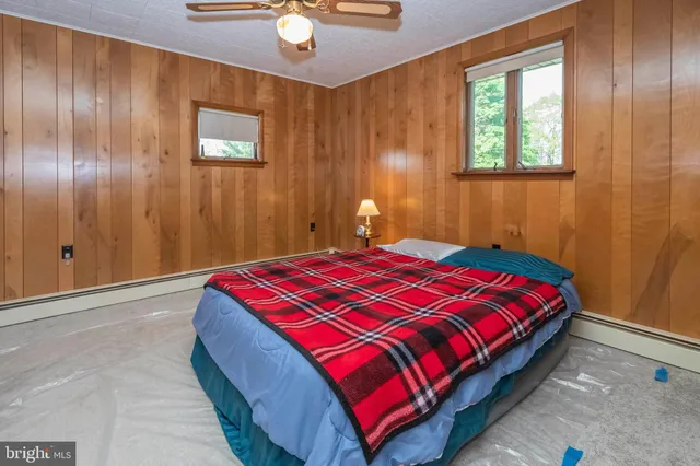 a bedroom with a bed and a dresser with mirror