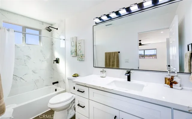 a bathroom with a sink a toilet a mirror a bathtub and shower