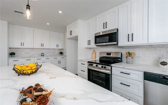 a kitchen with stainless steel appliances white cabinets and a stove