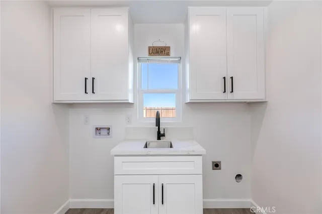 a kitchen with white cabinets and sink