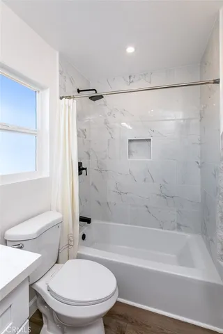 a bathroom with a toilet and a bath tub