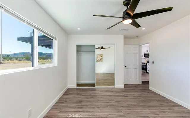 a view of empty room with wooden floor and window