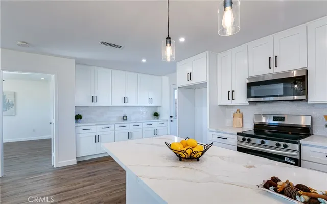 a kitchen with stainless steel appliances a stove a sink a refrigerator and cabinets