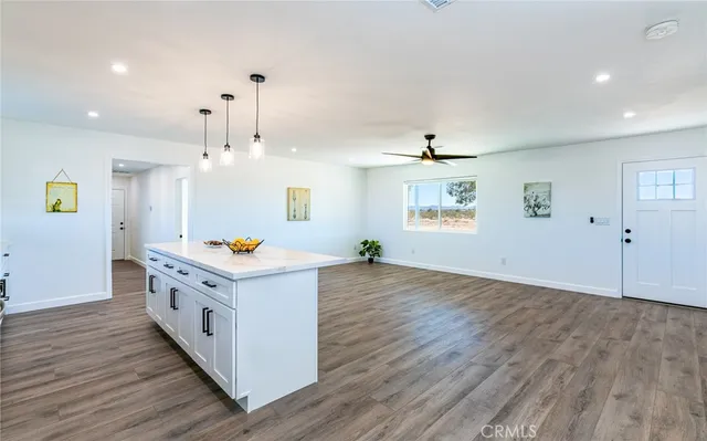 a kitchen with wooden floor and white cabinets
