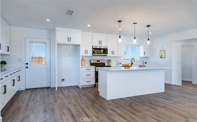 a kitchen with cabinets wooden floor and a sink